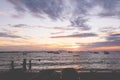 Silhouette of children of fisherman town play on the beach in sunset.