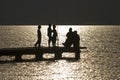 Silhouette of children fishing on a gangway