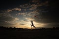 Silhouette of children flying a kite on sunset