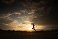 Silhouette of children flying a kite on sunset