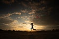 Silhouette of children flying a kite on sunset