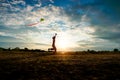 Silhouette of children flying a kite on sunset