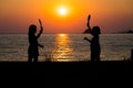 Silhouette of children playing tennis with sunset sun on a beach Royalty Free Stock Photo