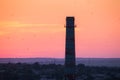 Silhouette of a chimney with flying birds at sunset. Colorful red sky. Industrial landscape. Royalty Free Stock Photo