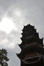 Silhouette of Chinese pagoda against bright sunlit grey sky
