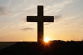 Silhouette of Christian cross outdoors at sunrise. Religion