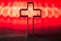 Silhouette of christian cross on red background, soft bokeh lights background. Copy space. Church worship, salvation Royalty Free Stock Photo