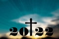 Silhouette of Christian cross with 2022 years at sunrise background. Concept of Christians new year 2022.Welcome merry Christmas Royalty Free Stock Photo