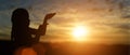 Silhouette of christian little girl open hands to praying for blessing from god at sunset background Royalty Free Stock Photo