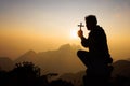 Silhouette of christian man hand praying, man holding a crucifix praying, spirituality and religion, woman praying to god. Royalty Free Stock Photo