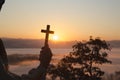 Silhouette of christian Man holding a cross cross in hands praying for blessing from god on sunlight background, hope concept Royalty Free Stock Photo