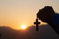 Silhouette of christian young woman praying with a cross at sunrise, Christian Religion concept background Royalty Free Stock Photo