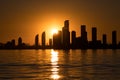 Silhouette of a city skyline at sunset reflecting in water. Royalty Free Stock Photo