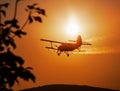 Silhouette of classic agricultural biplane at sunset