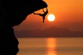 Silhouette of climber on a cliff against beautiful red sky sunset Royalty Free Stock Photo