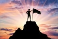 Silhouette of a climber with a flag on the top of the mountain which he subdued Royalty Free Stock Photo