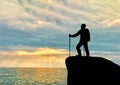 Silhouette of a climber on top looks afar at sea