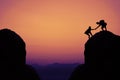 Silhouette of climbing people in mountains as symbol for team sp