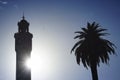 Silhouette of clock tower and palm tree in Izmir - sun and clear blue sky in contrast Royalty Free Stock Photo