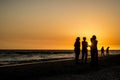 Silhouette cluster of people on the oceanfront.