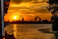 Silhouette of the coastline of Kherson Ukraine with port cranes at the dock in the orange rays of the sunset. View of the city