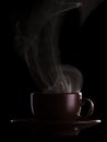 Silhouette coffee cups with saucer and hot steam isolated on black