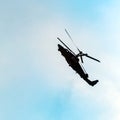 Silhouette of combat helicopter doing maneuvers