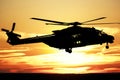 Silhouette of a combat helicopter at sunset in the sky, side view, air transportation Royalty Free Stock Photo