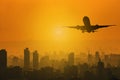 Silhouette of commercial plane flying over a city during with skylight sunset with copy space for text Royalty Free Stock Photo