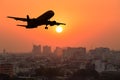 Silhouette commercial plane flying over city during sunset Royalty Free Stock Photo