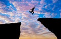 Silhouette concept idea.man jumping over cliff . Royalty Free Stock Photo