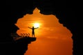 The Silhouette concept of new year 2020, Man standing and climbing in the cave or high cliffs at a red sky sunset Royalty Free Stock Photo