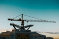 Silhouette of a construction crane over a high-rise building Royalty Free Stock Photo