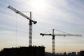 Silhouette of construction crane and workers on unfinished residential building against sunshine Royalty Free Stock Photo