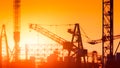 Silhouette construction cranes against backdrop of orange sunset, Generative AI Royalty Free Stock Photo