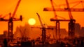 Silhouette construction cranes against backdrop of orange sunset, Generative AI Royalty Free Stock Photo