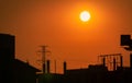 Silhouette construction site with orange sunset sky background. High voltage electric tower. Beautiful big sun at sunset Royalty Free Stock Photo