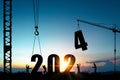 Silhouette of construction worker with crane and cloudy blue sky for preparation of welcome 2024 new year party and change new
