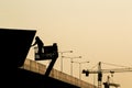 Silhouette of construction worker on scaffolding in the construction site before to night time Royalty Free Stock Photo