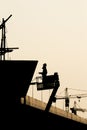 Silhouette of construction worker on scaffolding in the construction site before to night time Royalty Free Stock Photo