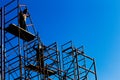 Silhouette of construction workers against sky on scaffolding wi