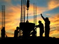 Silhouette construction workers are casting concrete in sunrise sky background Royalty Free Stock Photo