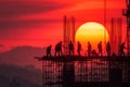 silhouette of construction workers working on a tall building at sunset Royalty Free Stock Photo