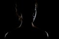 Silhouette contour of a beautiful brunette girl. Side lit studio portrait on dark background