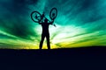Silhouette, contour of byciclist rising bike and celebrating. Action of succesful people winning contest