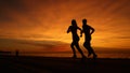SILHOUETTE: Unknown athletic couple running along calm ocean at orange sunset. Royalty Free Stock Photo