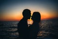 Silhouette of a couple at the beach at sunrise sky summer time, seashore summer beach at yellow blue evening horizon sea