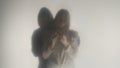 Silhouette of a couple behind a frosted curtain or glass close up. Man puts his arm around the shoulders of a sad woman Royalty Free Stock Photo