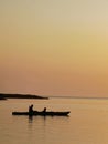 silhouette of a couple on a boat in the sea at sunset Royalty Free Stock Photo