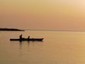 silhouette of a couple on a boat in the sea at sunset Royalty Free Stock Photo